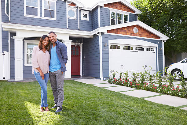 happy black couple standing outside their house